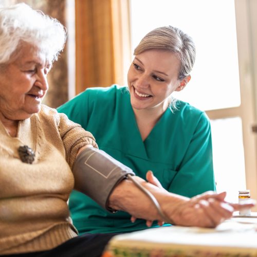 Female,Caretaker,Measuring,Senior,Woman's,Blood,Pressure,At,Home